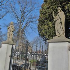 Čtyři sochy na ohradní zdi hřbitova a hrob