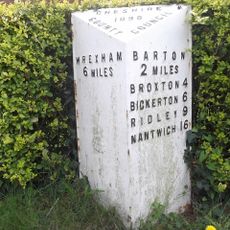 Milepost, between crossroads with B6130, in front of Milestone House