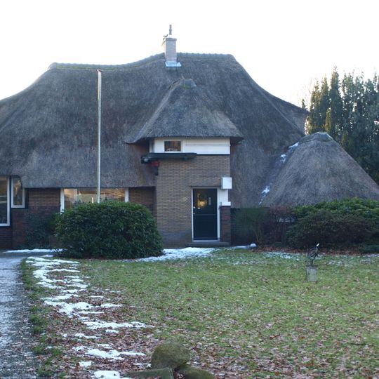 Villa met aangebouwde schuur met elementen uit de Amsterdamse Schoolstijl en de Engelse landhuisstijl