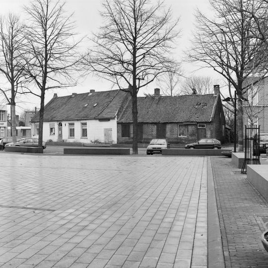Pand zonder verdieping, onder pannen zadeldak, dat links aansluit tegen een puntgevel en rechts doorloopt over nr 14