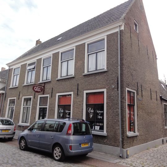 Dwarshuis onder zadeldak tussen zij-topgevels, vijf traveeën breed en met bovenverdieping