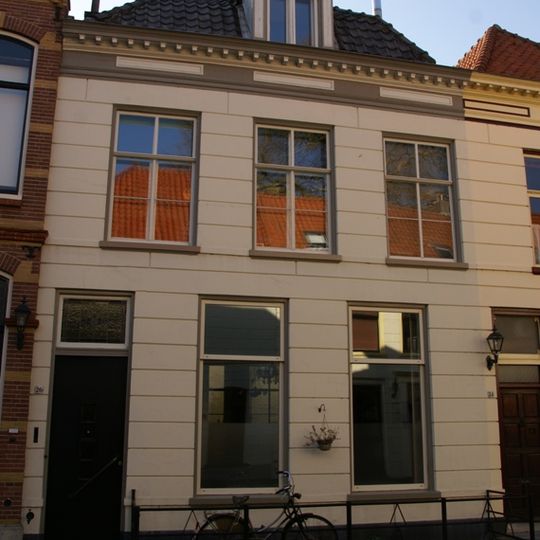 Huis met gepleisterde lijstgevel met in de verdieping schuiframen en dakvenster met balustrade
