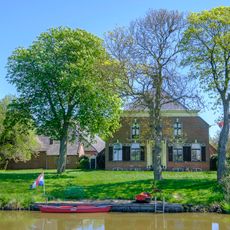 Stookhok met aangebouwde muur met poort naar de boerderij