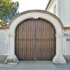 Madonnenfigur und barocker Steinbogen des Pfarrhofs