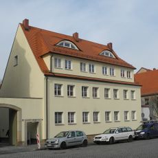 Wohnhaus (Nr. 16) in offener Bebauung, Hinterhaus (Nr. 16a), Scheune und seitliche Hofmauer mit Torbogen und Pforte Am Markt 16; 16a
