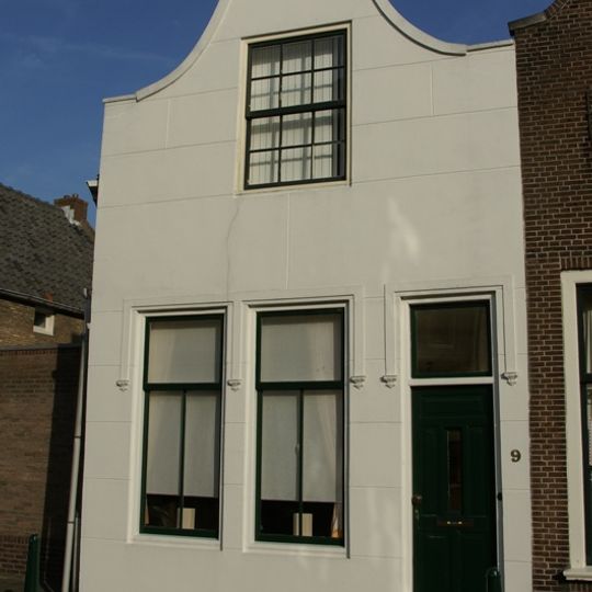 Huis met gepleisterde tuitgevel met stoep