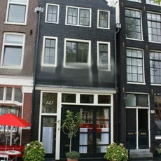 Pand met gevel onder klokvormige top met rollagen