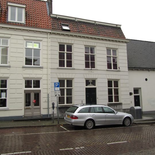 Huis met gebosseerd gepleisterde lijstgevel