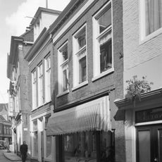 Pand met rechte kroonlijst en zesruits vensters op de verdieping