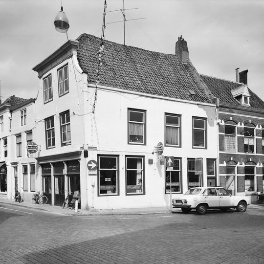 Apart genummerde ingang in gepleisterde zijgevel van hoekhuis vlasmarkt