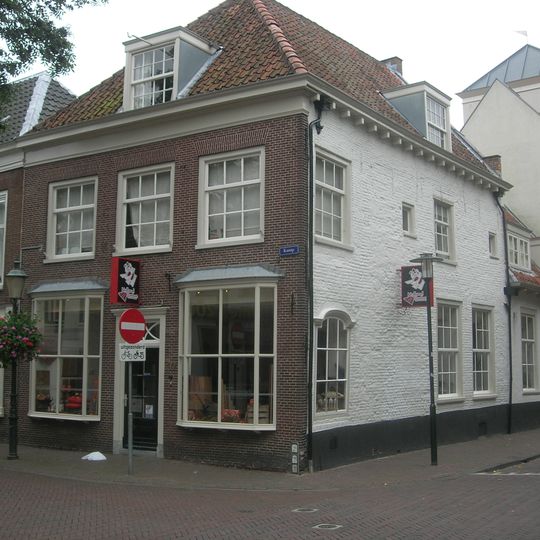 Huis met lijstgevel. Zijgevel gepleisterd en gewit