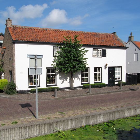 Hoekpand Lange Taam. Dwarshuis van parterre en lage verdieping onder zadeldak tussen gepleisterde puntgevels. De vensters van de verdieping hebben oude kozijnen en roedenverdeling, alsmede luiken