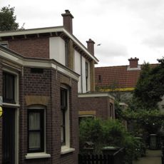 Blok van vier rug-aan-rug gebouwde woningen op vierkante plattegrond, bestaande uit begane grond en verdieping onder een plat dak