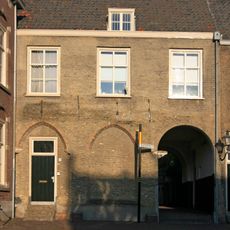 Woonhuis tegen de noordgevel van de Augustijnenkerk in de hoek tussen het schip dezer kerk en de kloostergang. Lijstgevel, late Empire ramen en schilddak.