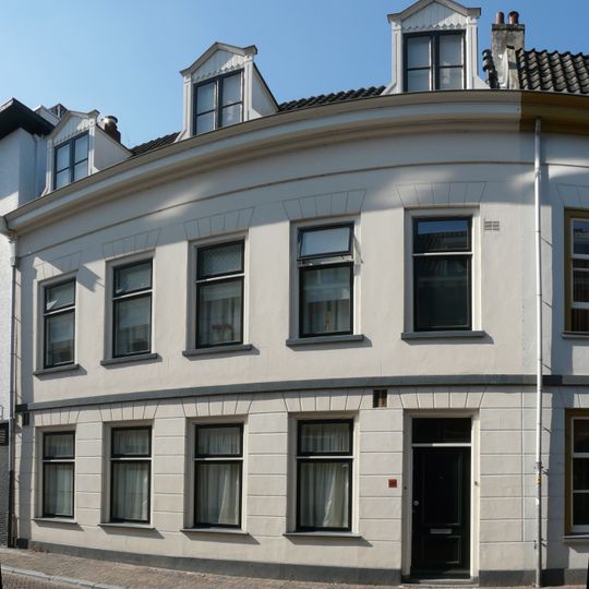 Pand met verdieping onder dwarsgeplaatst pannen zadeldak, gepleisterde lijstgevel