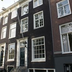 Huis onder dwars dak met gevel onder rechte lijst met consoles, evenals de deuromlijsting