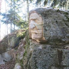 Skalní reliéf Troll u lesní cesty v Brništi