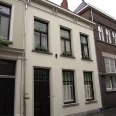 Huis met dwars schilddak en gepleisterde lijstgevel