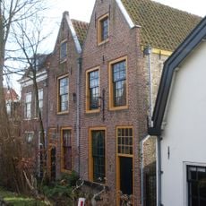 Pand met gepleisterde gevel met rechte kroonlijst en delen van een uithangteken