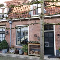 Woonhuisje van alleen begane-grond onder hoog schilddak, dat in mansardevorm gewijzigd is