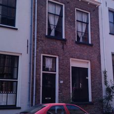 Pand onder gewijzigd zadeldak, dat links wordt afgesloten door een gotische puntgevel