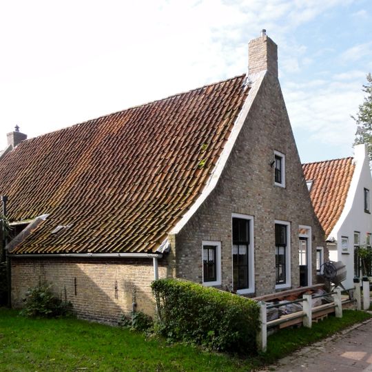 Pand met zesruitsvensters en houten goot op blokjes onder aan de voorzijde afgewolfd zadeldak