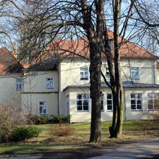 Herrenhaus über winkligem Grundriss, Gutspark und umgebende Einfriedungsmauer mit drei Torzugängen eines ehemaligen Rittergutes sowie Aussichtspunkt mit Linde an der Kamenzer Straße Parkstraße 11, 13