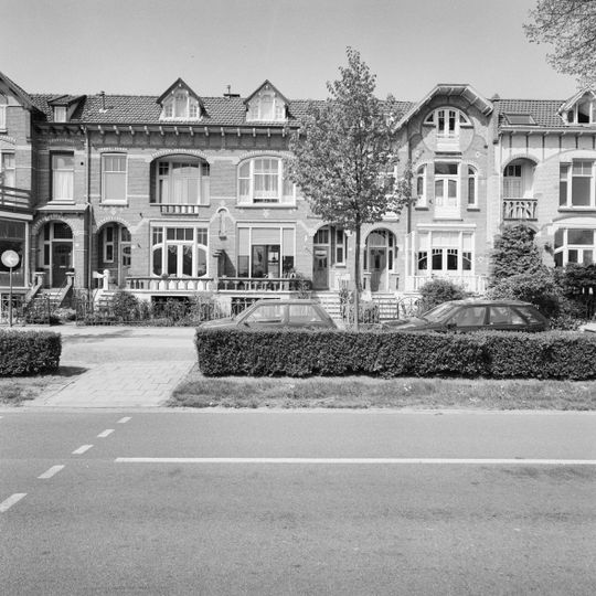 Twee identieke, spiegelbeeldig ten opzichte van elkaar geschakelde herenhuizen met tuinhek