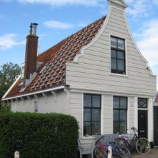 Houten huis. Uit- en ingezwenkt voorschot (XIXa). Goede pui; empire deur en bovenlicht in omlijsting; gepotdekselde rechterzijwand