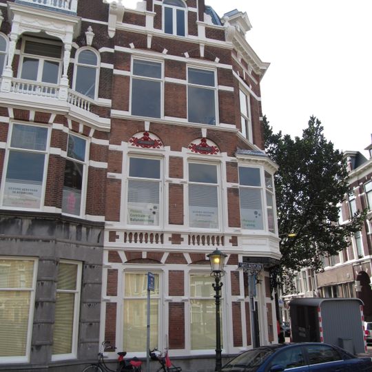 Hoekpand Reinkenstraat in neo-renaissance trant. Pand met afgeschuinde hoek en trapgevels, gedateerd op cartouches. Versiering van banden, blokken en ontlastingsbogen.