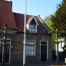 Huis onder zadeldak met langsgevel aan de straat. Schuiframen met negen ruiten. Kap 19e-20e eeuw gewijzigd