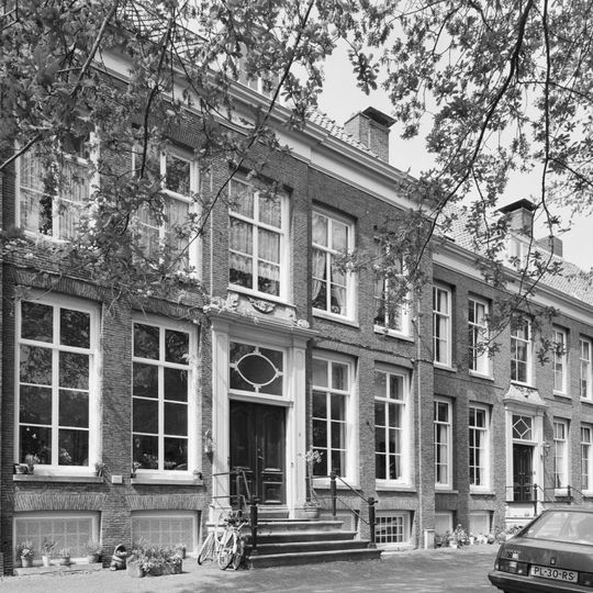 Pand met vooruitspringende sobere lijstgevel en stoep, versiering boven de deur