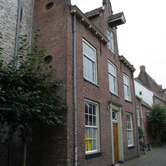 Huis met gepleisterde gevel met in de middenpartij topgevel met hijsbalk
