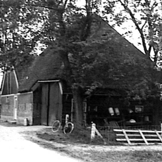 Stolpboerderij, aan de rand van het dorp gelegen, houten topgevel boven het woongedeelte. In de top een vlieringluik. Zijwand van hout
