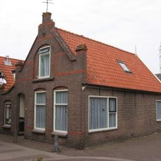 Woonhuis waarvan de achtergevel oud is met houten voorschot waarin vlieringluik