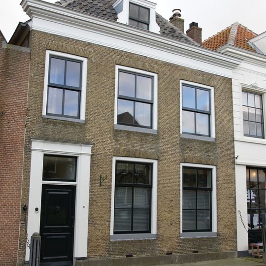 Huis onder schilddak en met lijstgevel in gele baksteen