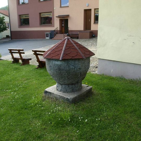 Kamenná křtitelnice u kostela svatého Mikuláše v Heřmanově