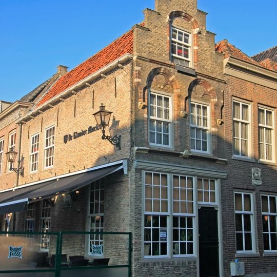 Pand met trapgevel met jonische pilasters, friezen met metselmozaïek en geprofileerde dekplaten