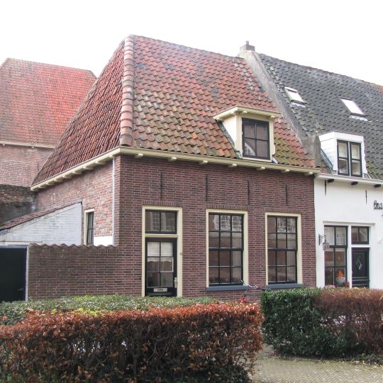 Laag huisje onder zadeldak tussen puntgevels