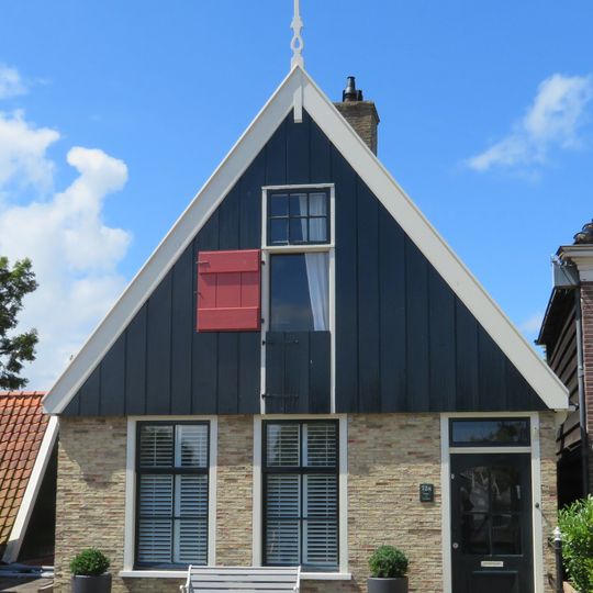 Pand onder zadeldak tegen topgevel met houten voorschot: in de top houten makelaar