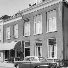 Herenhuis met eenvoudige, bakstenen lijstgevel. Schilddak met topschoorsteen, waarop een windkap. Dubbele deur uit de bouwtijd, hardstenen vensterdorpels. Hardstenen stoeppalen met kettingen