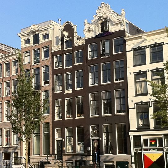 Pand met gevel onder verhoogde gesneden lijst met kuifstuk