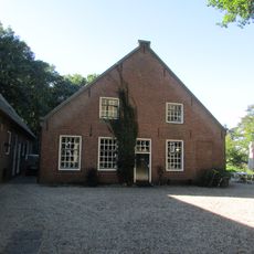 Boerderij met pannen zadeldak tussen bakstenen topgevels met beitels