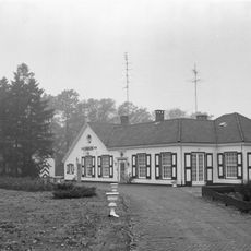 Buitenhuis met alleen begane grond met schilddak en links een puntgevel