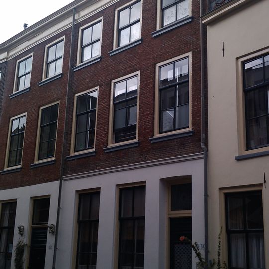 Pand onder dwars schilddak met brede lijstgevel waarin vensters met geprofileerde dorpels en in de verdiepingen empire-ramen