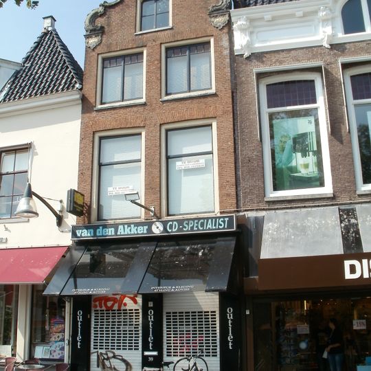 Pand onder zadeldak tegen klokgevel met rococo-beeldhouwwerk