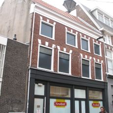 Pand met lijst met natuurstenen blokken boven de vensters, bovendeel verhoogd, beneden verbouwd