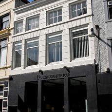 Huis onder met rode pannen belegd schilddak en met witte lijstgevel