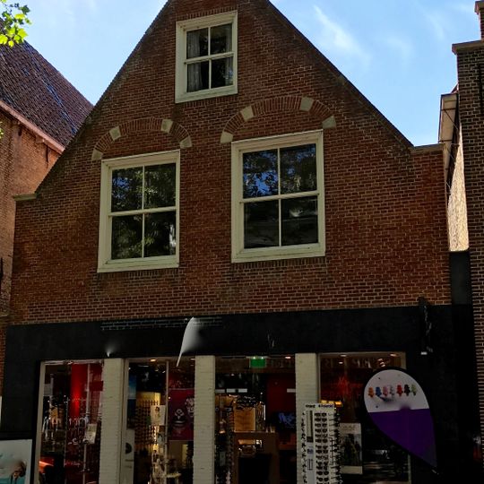 Pand met vernieuwde topgevel met herplaatste boogblokken, geprofileerde kozijnen en jaartalankers