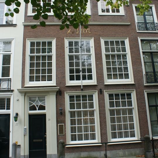 Pand met in latere tijd verhoogde gevel met versierde deurpartij